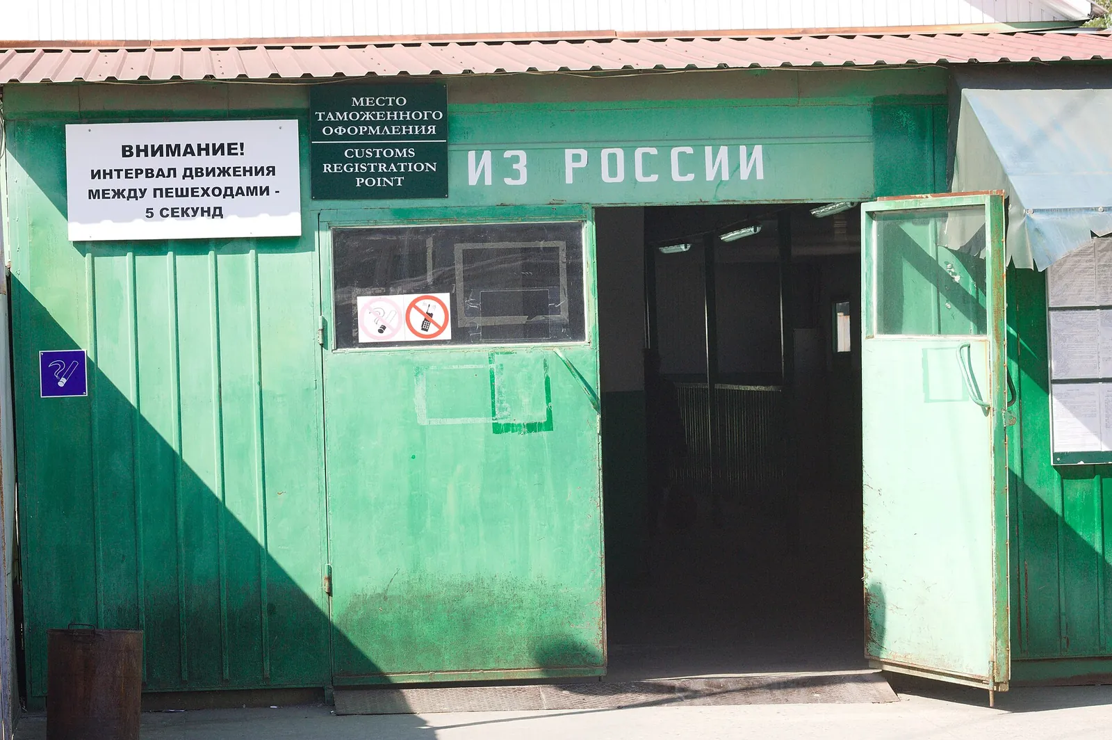 Зелёный павильон места таможенного оформления с надписью «Из России» на переходе Псоу